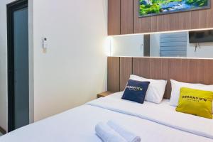 a bedroom with a bed with yellow and blue pillows at Urbanview SANT Hotel Syariah near Stasiun Tegal in Tegal
