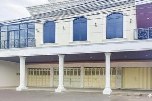 a white building with blue windows and doors at Urbanview SANT Hotel Syariah near Stasiun Tegal in Tegal