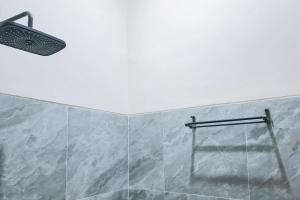 a shower with a glass door and a light at Urbanview SANT Hotel Syariah near Stasiun Tegal in Tegal