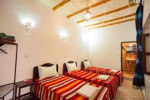 Habitación con 2 camas y lavamanos en La Terrasse des Delices, en Ouarzazate