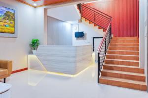 a staircase in a building with a red wall at Urbanview SANT Hotel Syariah near Stasiun Tegal in Tegal