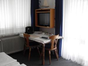 a room with a desk with two chairs and a television at Haus Edith Privathaus mit Gästezimmern in Bregenz