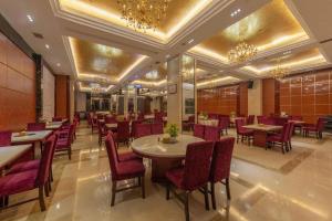une salle à manger avec tables, chaises et lustres dans l'établissement Xin Sheng Da Hong Sheng International Hotel, à Kunming