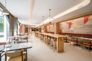 a cafeteria with tables and chairs in a room at Home Inns Plus Shanghai Xujiahui Branch in Shanghai