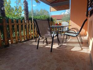 a patio with two chairs and a table on a patio at Holiday Home Višnja with Pool in Benkovac