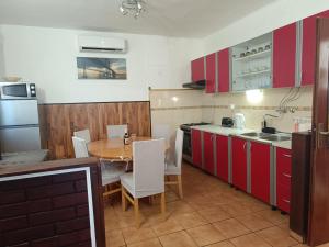 a kitchen with red cabinets and a table with chairs at Holiday Home Višnja with Pool in Benkovac