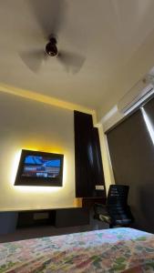 a bedroom with a flat screen tv on the wall at Heavenly stays in Greater Noida