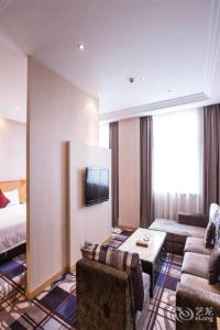 una habitación de hotel con un sofá y una cama en Zhangjiagang Jiangnan Garden Hotel, en Xiwujieqiao