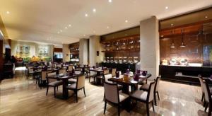 a restaurant with tables and chairs and a bar at Kinho Narada Hotel in Xianliangzhongchang
