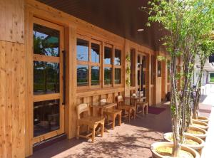 ein Holzgebäude mit Tischen, Stühlen und Topfbäumen in der Unterkunft Semerah Garden Hotel in Pontian Kecil