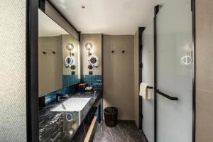 un baño con lavabo y espejo en Four Points by Sheraton Yantai Zhifu, en Yantai