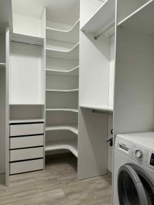 eine Waschküche mit weißen Schränken und einer Waschmaschine in der Unterkunft ApartamentywInie in Inowrocław