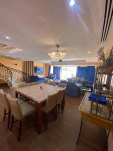 una sala de estar con una mesa y un sofá en درة العروس فيلا بلويتش الازرق, en Durat Alarous