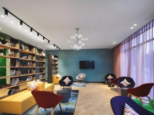 d'un salon avec un canapé et des fauteuils jaunes. dans l'établissement Campanile Hotel Huaibei Yuxi, à Suixi