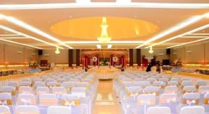 a large banquet hall with white chairs and tables at Zahra Syariah Hotel Kendari in Pipulu