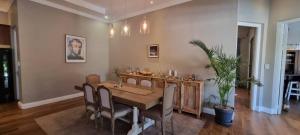 a dining room with a table and a potted plant at Safari Villa Botique Hotel in Windhoek