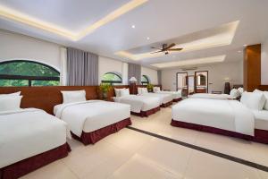 a room with a bunch of beds in it at Sơn Nữ Emerald Hill Hotel in Bak Kan