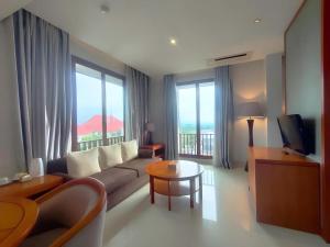 a living room with a couch and a table at eL Hotel Kartika Wijaya Batu in Songgoriti