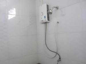 a shower in a white bathroom with a shower head at The Palm Village in Ban Non Chan +55 photos