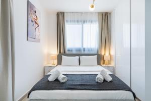 une chambre avec un grand lit avec des serviettes dessus dans l'établissement Jas Living - Chic Apts & Balconies in Larnaca, à Larnaka