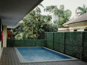 a swimming pool in a yard next to a fence at Sofyan Hotel Cut Meutia Family Friendly in Jakarta