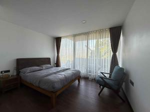 een slaapkamer met een bed, een stoel en een raam bij Villa by Bellavista in Pātan