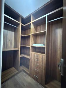 een inloopkast met houten kasten en planken bij Villa by Bellavista in Pātan