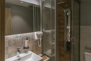 a bathroom with a sink and a glass shower at Trofonios Boutique Hotel in Levádeia +73 photos