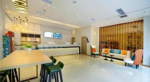 un hall avec une table et des chaises dans un bâtiment dans l'établissement City Comfort Inn Chongqing Jiangbei Airport T3 Terminal, à Chongqing