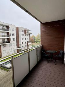 einen Balkon mit einem Tisch und Blick auf ein Gebäude in der Unterkunft ApartamentywInie in Inowrocław