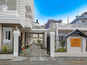 une grande maison blanche avec une passerelle dans l'établissement Da Yatra Courtyard Hotel & Resort, à Pokhara