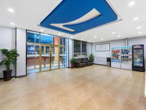 天津市にある7Days Inn Tianjin Dongli Development Zone Light Railway Stationの青い天井の大きなロビー