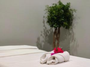 Dos toallas blancas con una flor roja sobre una cama. en Chambers Mahabaleshwar, A Club Mahindra Associate Resort, en Mahabaleshwar