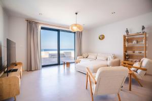 un salon avec un canapé et une table dans l'établissement Villa Deep Blue Modern Seaview Villa with Infinity Pool near Lido Beach, à Orga