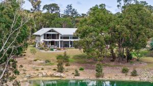 WilyabrupにあるHundred Acre Woodland Retreatの池のある家の空見