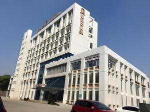 a white building with a red car parked in front of it at Jinjiang Inn Select Nanchang Liantang in Nanchang County