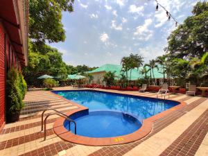 a swimming pool at a resort with chairs and a building at Chambers Mahabaleshwar, A Club Mahindra Associate Resort in Mahabaleshwar
