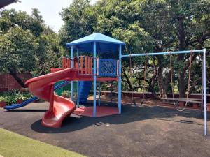 un patio de recreo con un tobogán en un parque en Chambers Mahabaleshwar, A Club Mahindra Associate Resort, en Mahabaleshwar