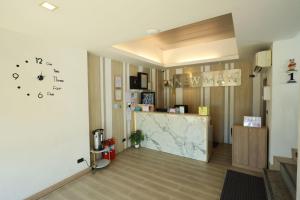 a room with a counter and a clock on the wall at Newman hotel in Ban Khlong Ha