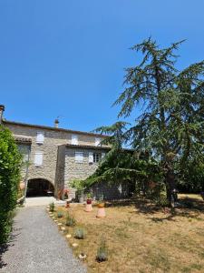 a house with a tree in front of it at Gîte de caractère tout confort "Au Clos des Ammonites chez Ange&Sébastien " in Labeaume