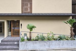 a house with palm trees in front of it at casana KYOTO in Kyoto