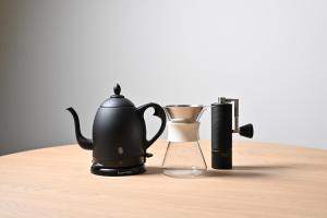a tea kettle and a cup on a wooden table at casana KYOTO in Kyoto