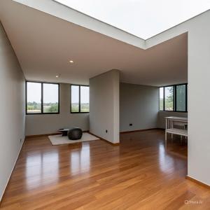 an empty living room with wood floors and windows at XyraaHouse Apart in Kinati