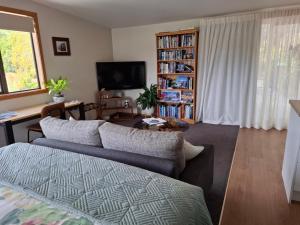 a living room with a couch and a book shelf at Channel View Havelock in Havelock
