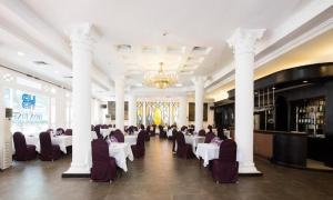 a banquet hall with white tables and chairs and a chandelier at Hoa Binh Hotel in Hanoi
