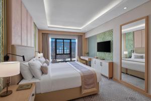 a bedroom with a large bed and a large mirror at Makarem Haram view suites in Al Madinah +44 photos