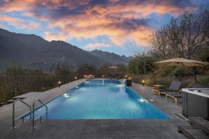 une piscine avec vue sur les montagnes dans l'établissement Echor Himalayan Aurum Manali, à Manali