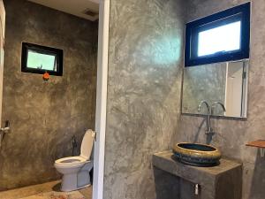 a bathroom with a toilet and a sink at บ้านสราญรัตน์ in Ban On Luai