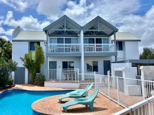 a house with a swimming pool and a blue chair at Waterfront Unit 4 - Kalbarri WA in Kalbarri