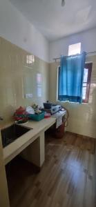 a kitchen with a counter with a sink and a window at Peace Yard in Dharmsāla